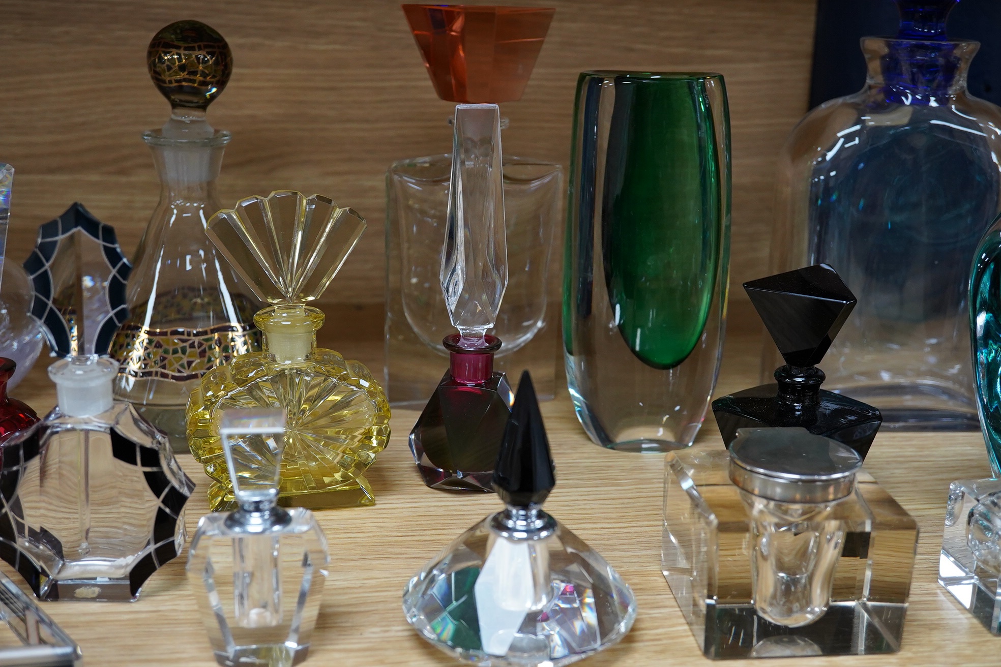 Eighteen glass scent bottles, two silver mounted, tallest 24.5cm, and a glass vase. Condition - good